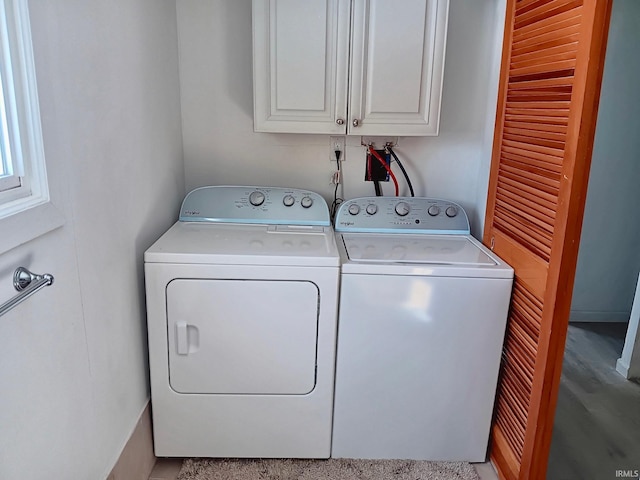 washroom featuring washer and dryer and cabinet space