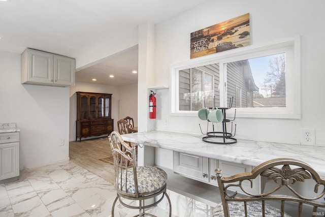 interior space featuring light stone countertops, recessed lighting, marble finish floor, and gray cabinetry