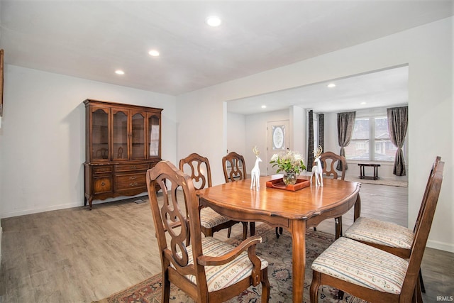 dining room with baseboards, wood finished floors, and recessed lighting