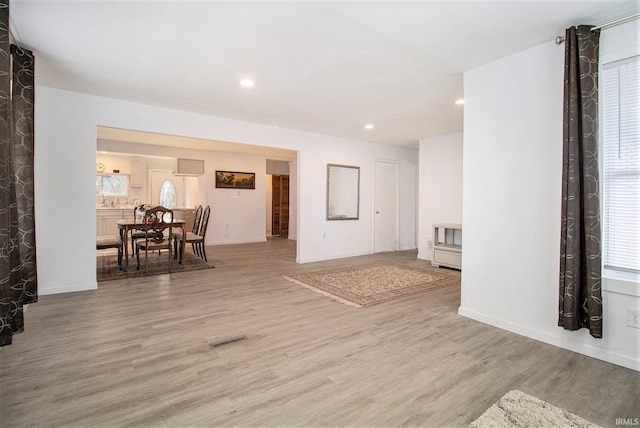 living room featuring a wealth of natural light, light wood-type flooring, visible vents, and recessed lighting