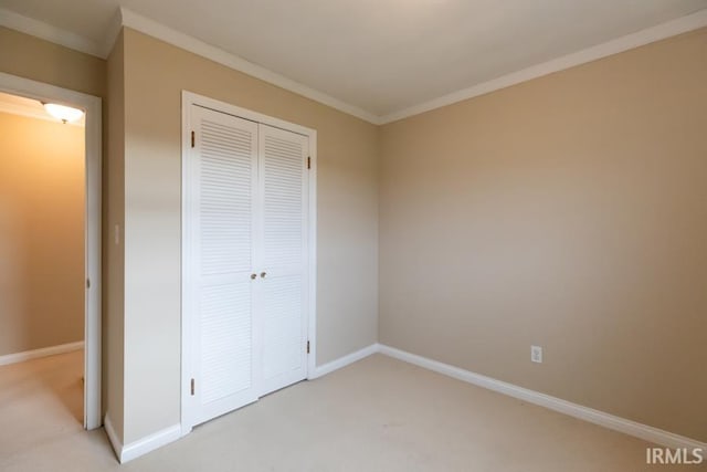 unfurnished bedroom featuring light colored carpet, a closet, and ornamental molding