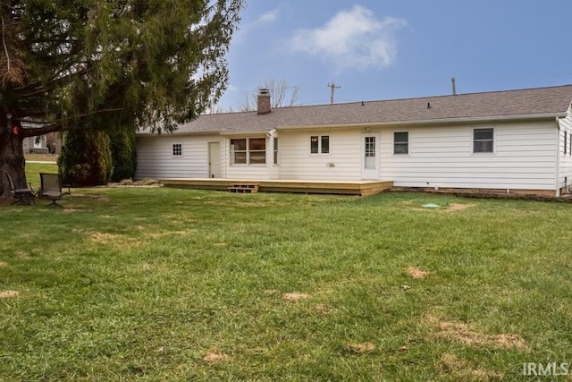 back of property with a wooden deck and a yard