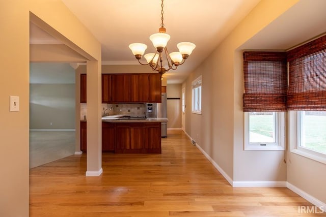 kitchen with an inviting chandelier, stainless steel fridge with ice dispenser, kitchen peninsula, pendant lighting, and light wood-type flooring