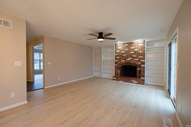 unfurnished living room with ceiling fan, a fireplace, and light hardwood / wood-style flooring