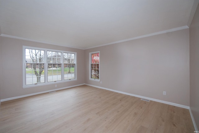 spare room featuring crown molding and light wood-type flooring