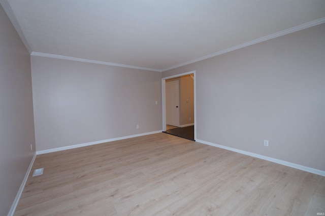 empty room featuring light hardwood / wood-style floors and crown molding