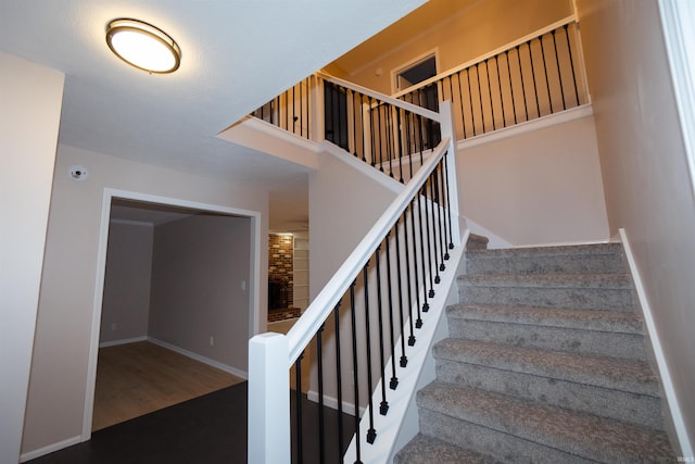 stairs with hardwood / wood-style floors and a towering ceiling