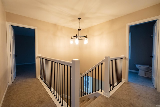 stairway featuring carpet and a notable chandelier