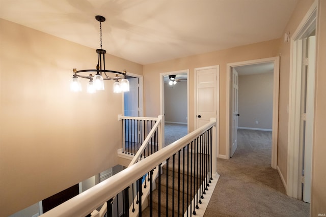 hall featuring carpet floors and a notable chandelier