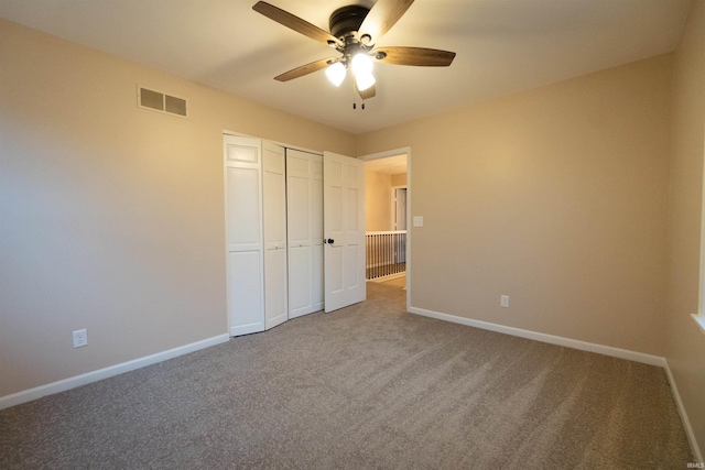 unfurnished bedroom with ceiling fan, carpet floors, and a closet