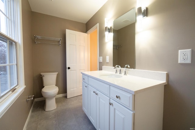 bathroom with tile patterned floors, plenty of natural light, vanity, and toilet