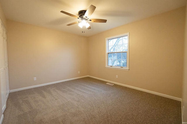 carpeted spare room featuring ceiling fan