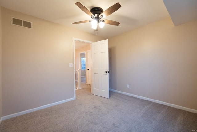 spare room with ceiling fan and light carpet