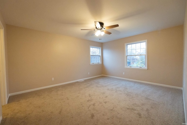 carpeted spare room with ceiling fan