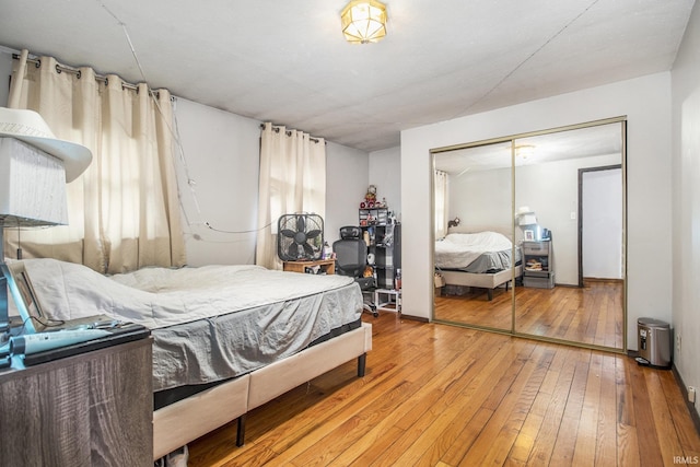 bedroom with wood-type flooring and a closet