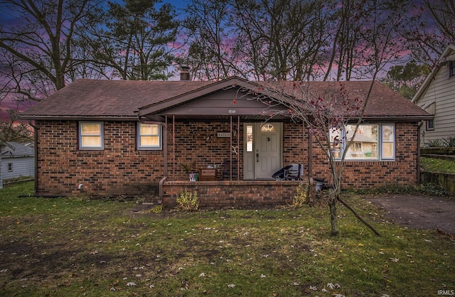 view of front facade featuring a porch and a yard