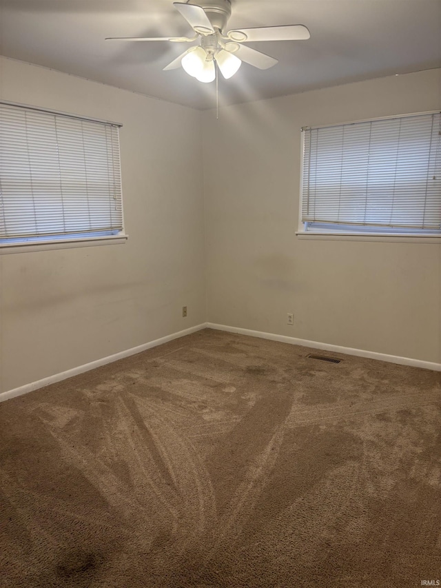 spare room with ceiling fan and carpet