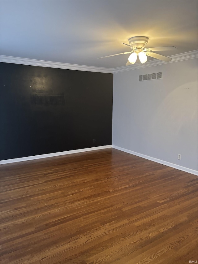 empty room with ceiling fan, dark wood-type flooring, and crown molding