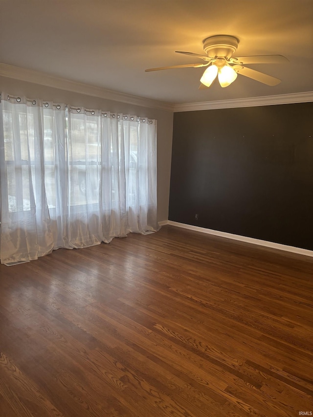 empty room with ceiling fan, dark wood-type flooring, and ornamental molding