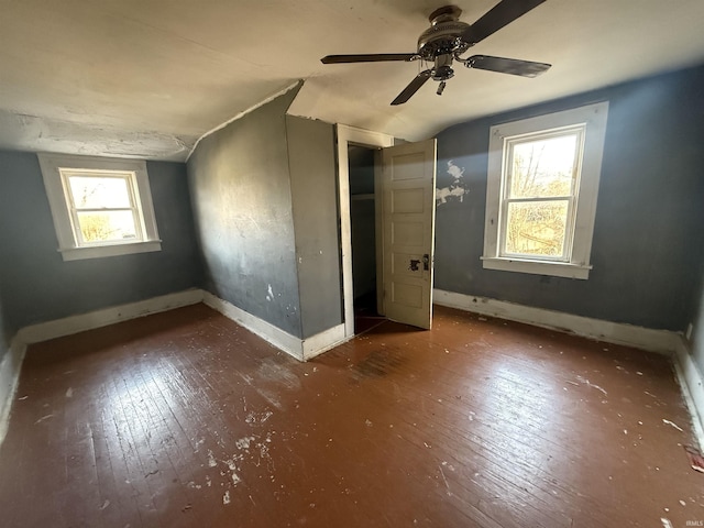 unfurnished bedroom with dark hardwood / wood-style flooring, vaulted ceiling, multiple windows, and ceiling fan