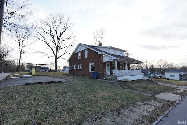 view of home's exterior with a lawn and covered porch