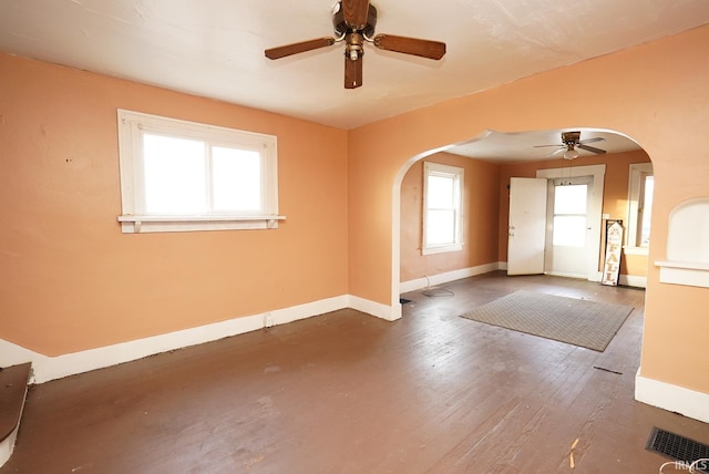 spare room featuring a wealth of natural light, dark hardwood / wood-style floors, and ceiling fan