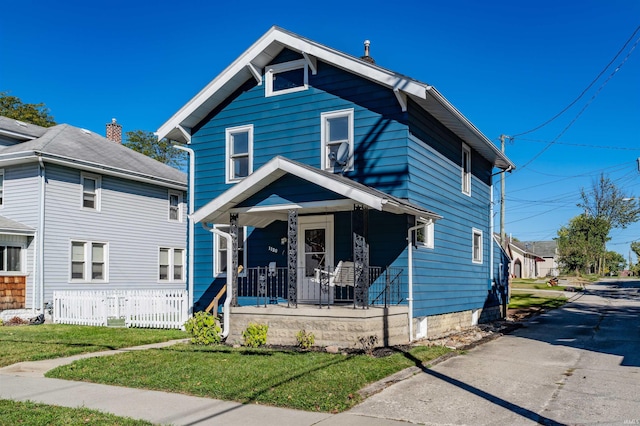 view of front of home with covered porch and a front yard