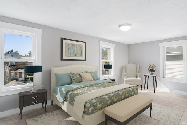 bedroom featuring light carpet and multiple windows