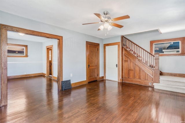 unfurnished living room with dark hardwood / wood-style flooring and ceiling fan