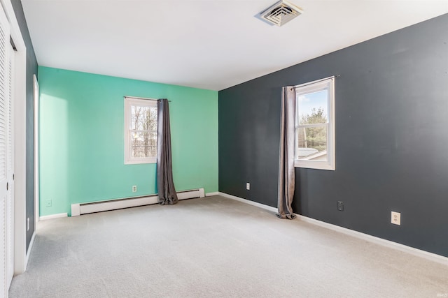 carpeted empty room featuring a baseboard radiator