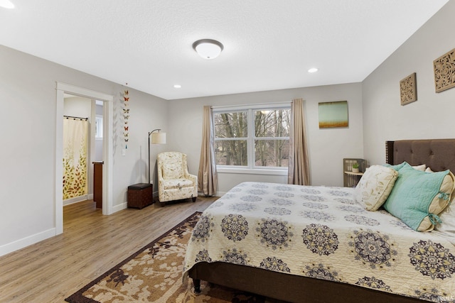 bedroom featuring a textured ceiling and light hardwood / wood-style floors