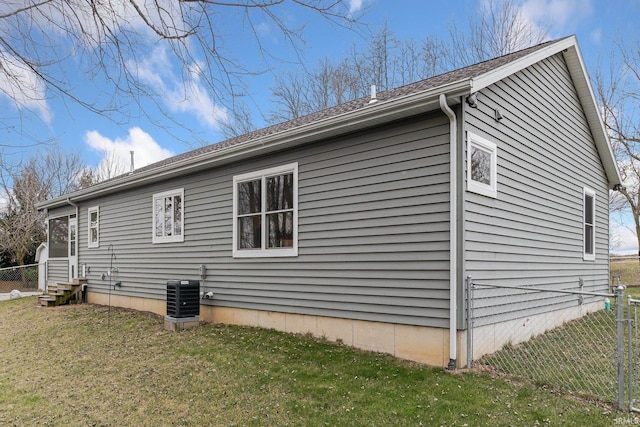 view of side of property featuring cooling unit and a yard