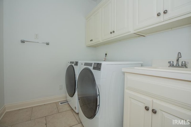 washroom with independent washer and dryer, cabinets, light tile patterned floors, and sink