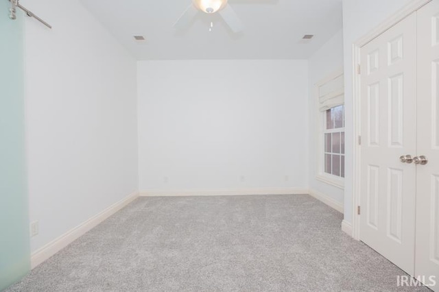 carpeted empty room featuring ceiling fan