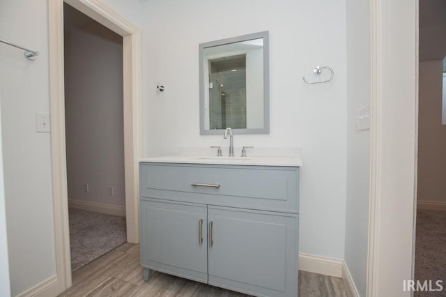 bathroom featuring a shower, hardwood / wood-style floors, and vanity