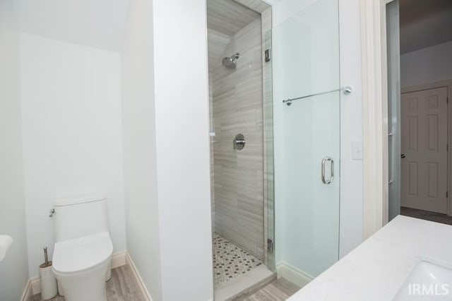 bathroom with hardwood / wood-style flooring, toilet, an enclosed shower, and vanity