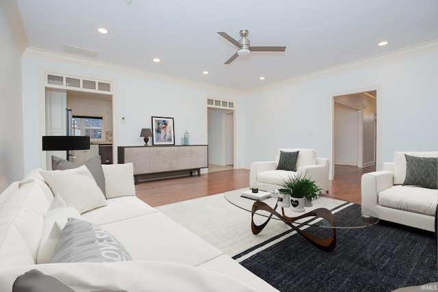 living room with ceiling fan, ornamental molding, and light hardwood / wood-style flooring