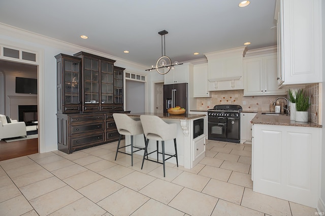 kitchen featuring a center island, black appliances, sink, decorative backsplash, and dark brown cabinetry