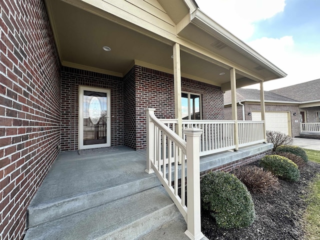 entrance to property featuring covered porch and a garage