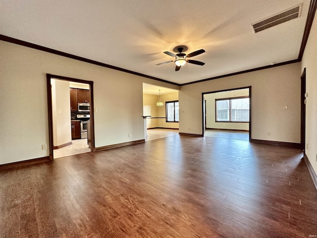 empty room featuring ceiling fan, wood-type flooring, and ornamental molding