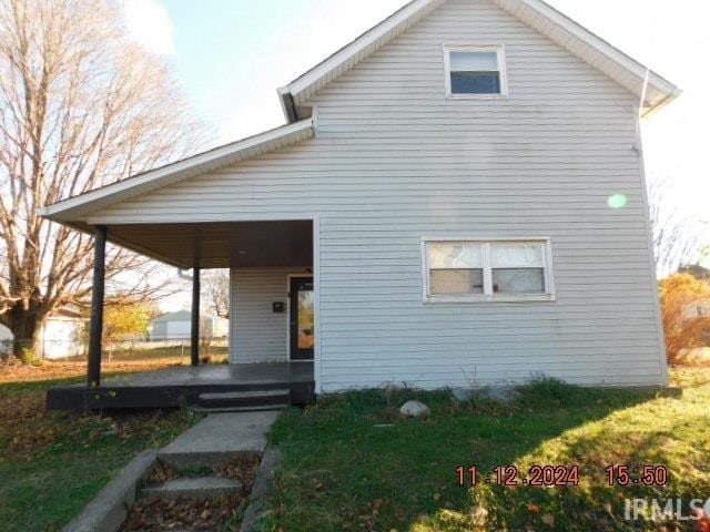 back of property featuring covered porch