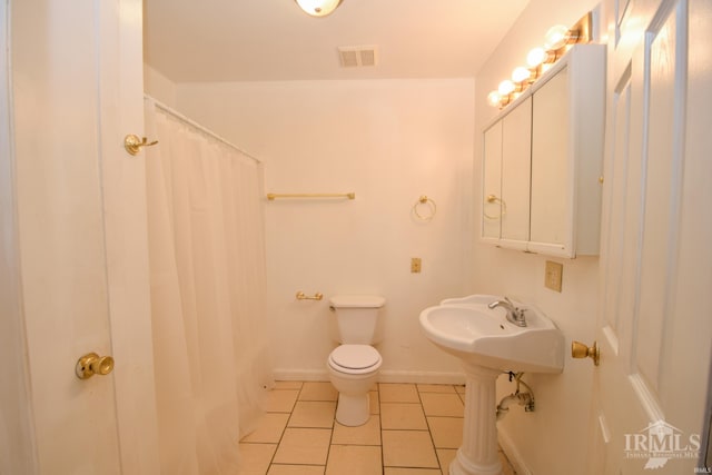 bathroom with a shower with curtain, tile patterned flooring, and toilet