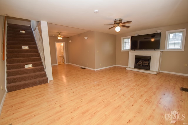 unfurnished living room featuring ceiling fan and light wood-type flooring