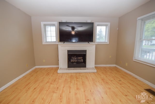 unfurnished living room featuring a wealth of natural light and light hardwood / wood-style flooring