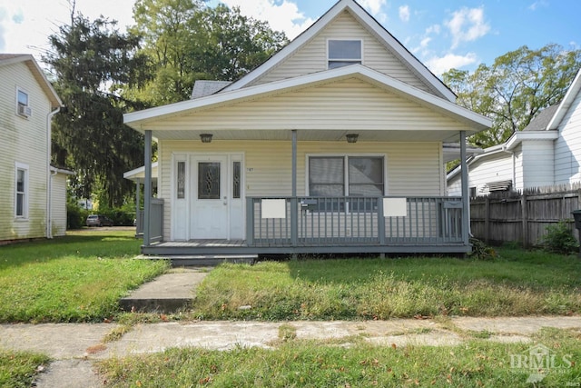 bungalow-style house featuring covered porch and a front lawn