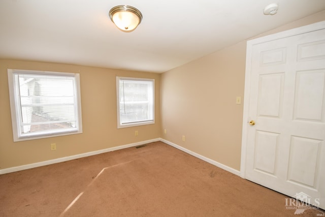 unfurnished room with carpet floors and vaulted ceiling