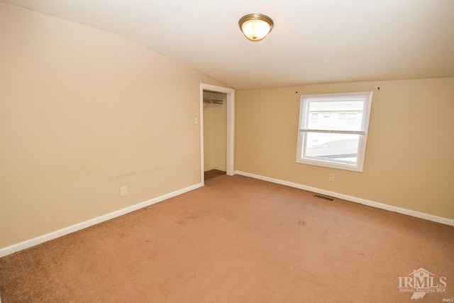 unfurnished room with carpet floors and vaulted ceiling