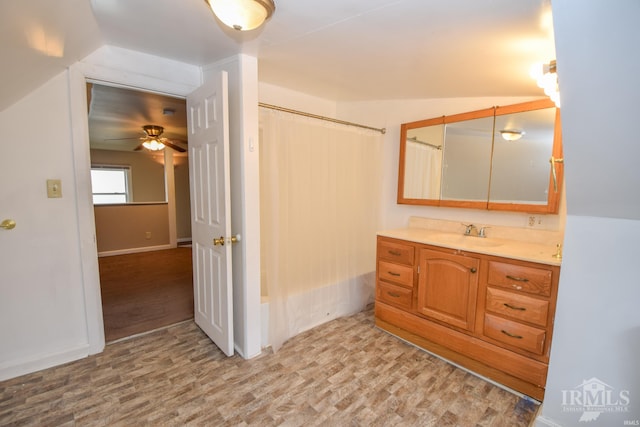 bathroom with vanity, hardwood / wood-style flooring, vaulted ceiling, and ceiling fan