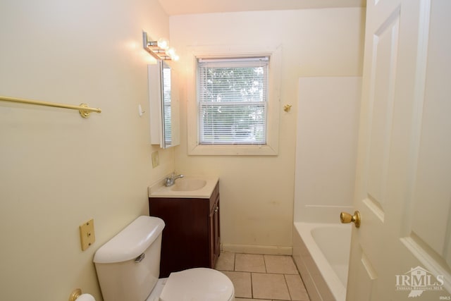 bathroom featuring toilet, vanity, tile patterned floors, and a bathtub