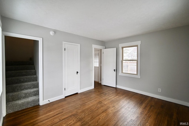 unfurnished bedroom with dark hardwood / wood-style floors